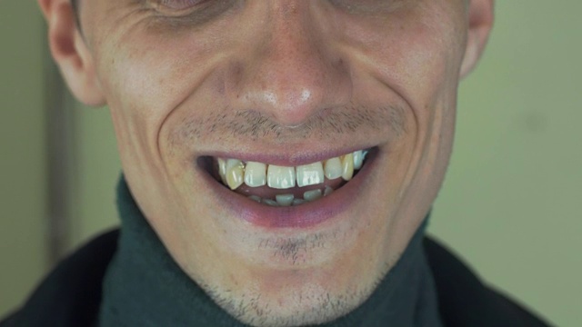 一个长着鬃毛的成年男子在镜头前唱歌。张开嘴。白的牙齿。微笑视频素材画面1
