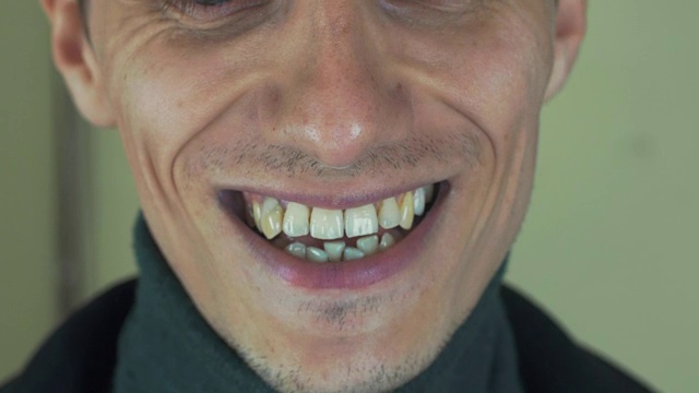 一个长着鬃毛的成年男子在镜头前唱歌。张开嘴。白的牙齿。微笑视频素材画面2