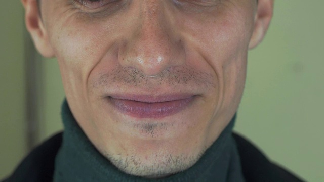 一个长着鬃毛的成年男子在镜头前唱歌。张开嘴。白的牙齿。微笑视频素材画面4