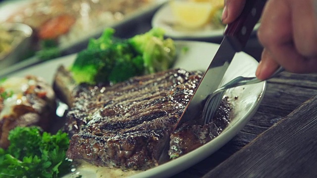 正在切的肋眼牛排里的骨头。视频下载