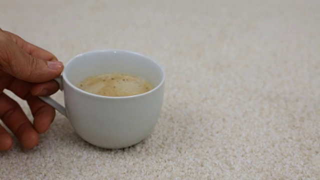 一杯咖啡掉了下来，洒在地毯上视频素材画面1