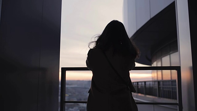 女人的剪影在高层摩天大楼看城市视频素材画面1