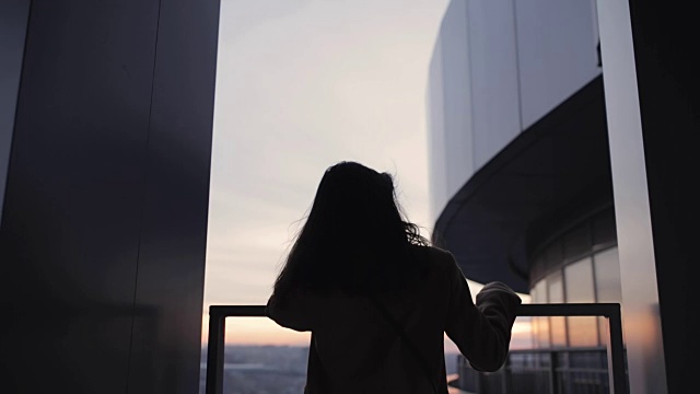 女人的剪影在高层摩天大楼看城市视频素材画面2