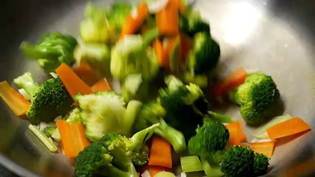 一个女人在煎锅里煮蔬菜的特写视频素材画面4