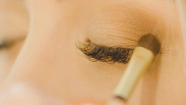 专业眼妆师，使用眼影粉。美丽的女人的脸。完美的妆容。美丽时尚。睫毛。近距离和慢动作视频素材画面3