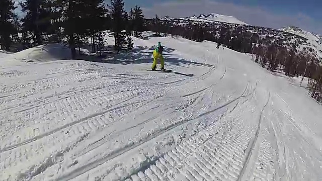 阳光明媚的一天，一个家伙骑着滑雪板从斜坡上滑下来视频素材