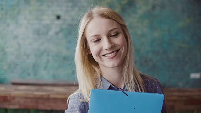 年轻白种金发女人的肖像看着照相机和微笑在现代办公室。工作上成功的员工视频素材画面4