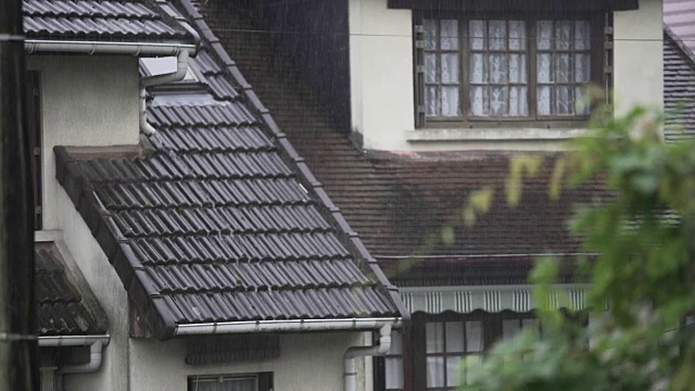 夏雨落在乡村的房子上，雨点沿着屋顶流下视频素材