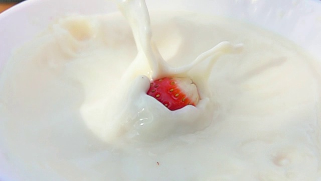 一半草莓和奶油一起掉在碗里视频素材画面1