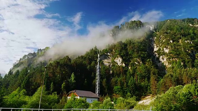 奥地利美丽的风景，从行驶的火车或汽车的窗口看到的景色。山顶上覆盖着森林和云彩的高山视频素材