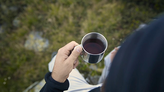 夏日户外日出时，年轻人在山上用金属杯喝茶视频下载