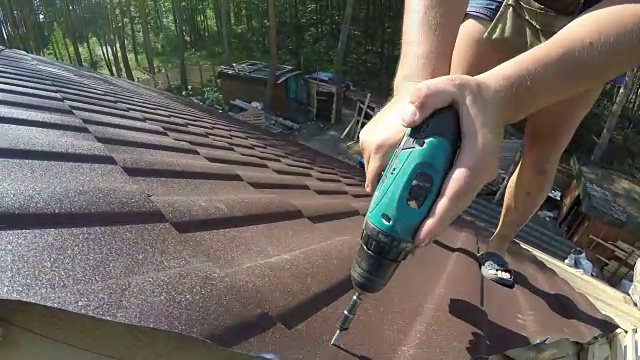 屋顶工用螺钉紧固金属屋面材料。视频素材画面3