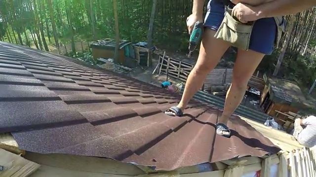 屋顶工用螺钉紧固金属屋面材料。视频素材画面4