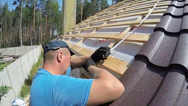 屋顶工人测量屋顶。视频素材画面2