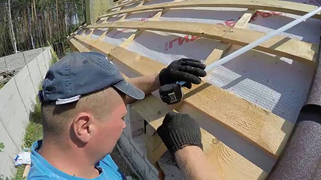 屋顶工人测量屋顶。视频素材画面4