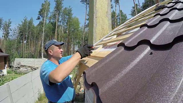 屋顶工人测量屋顶。视频素材画面2