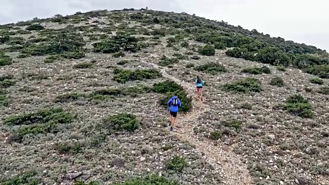 在地中海跟随一对夫妇跑上岩石山路视频素材