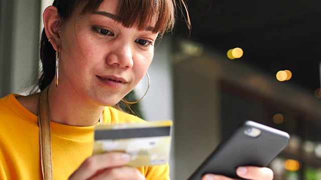 用智能手机刷信用卡的女人视频素材画面1