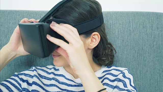 女人使用虚拟现实耳机。视频素材画面1