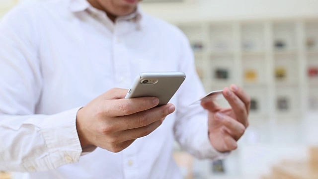 用手机和信用卡拉近双手视频素材画面2