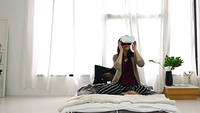 女人在卧室玩虚拟现实耳机视频素材画面4