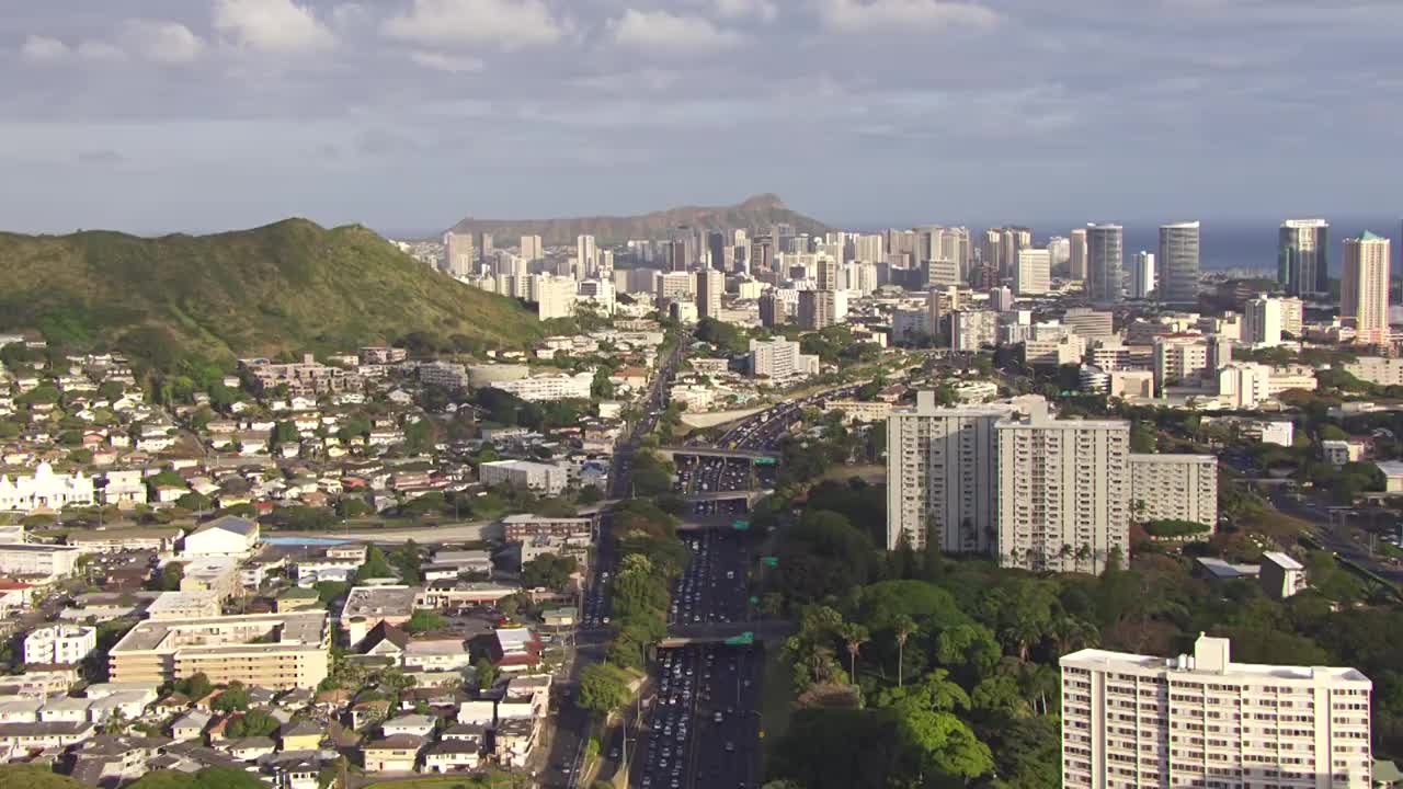 高速公路上的交通鸟瞰图，檀香山的天际线和钻石头的背景/夏威夷，美国视频素材