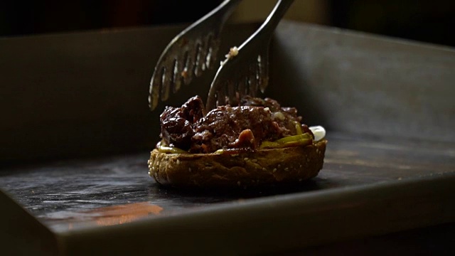 特写的主任把肉和炸汉堡。汁从肉里流出来。厨师正在做饭视频素材