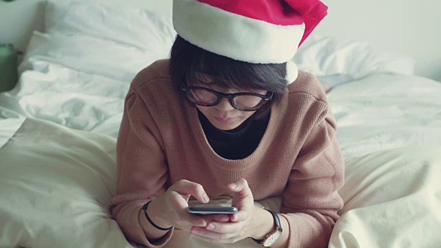 亚洲女性在客厅里用手拿着手机和信用卡。视频素材画面1