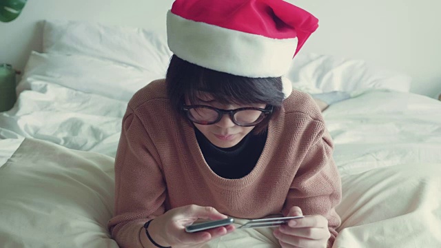 亚洲女性在客厅里用手拿着手机和信用卡。视频素材画面3