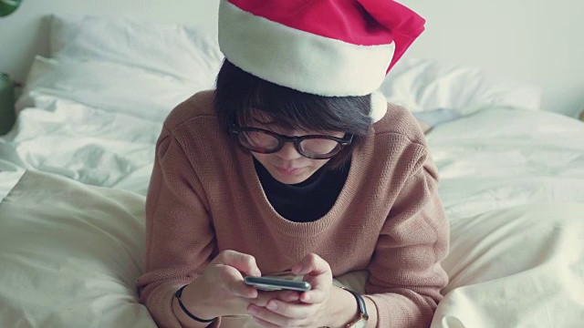 亚洲女性在客厅里用手拿着手机和信用卡。视频素材画面4