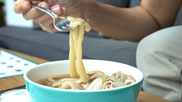 亚洲人吃日本乌冬面，慢动作镜头视频素材画面3