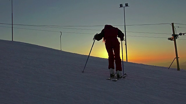 在夕阳下的滑雪坡上，滑雪靴与卡宾滑雪板相连。视频素材