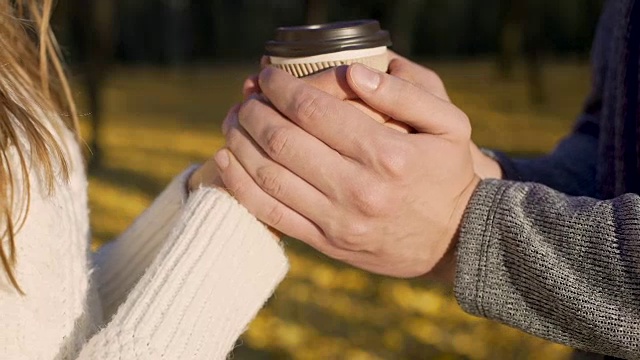 秋日里，情侣们用一杯热饮暖着他们冰凉的手视频素材