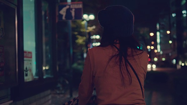 年轻的母亲推着婴儿车在城市的夜晚。视频素材画面3