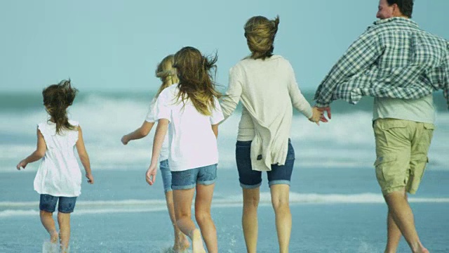 白人父母和年幼的女儿秋天去海滩度假视频素材画面1