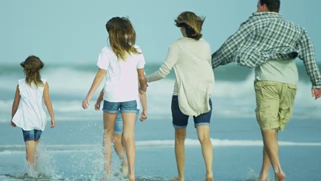 白人父母和年幼的女儿秋天去海滩度假视频素材画面2