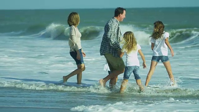 快乐的白人父母年轻的女儿在户外海滩散步视频素材画面2