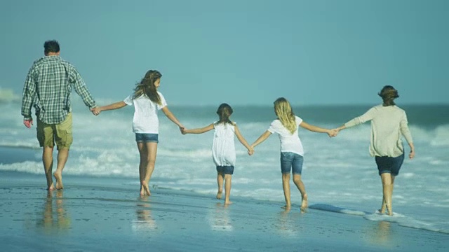 穿着随意的年轻白人家庭一起外出海滩视频素材画面1