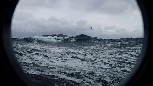 从波涛汹涌的海面上一艘船的舷窗里视频素材