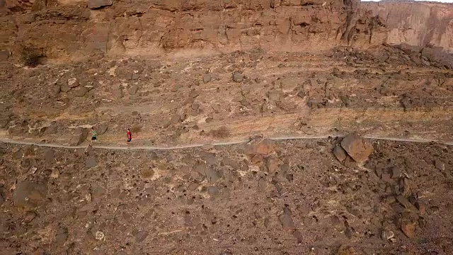 两名越野赛选手在峡谷上方的山道上冲刺视频素材画面1