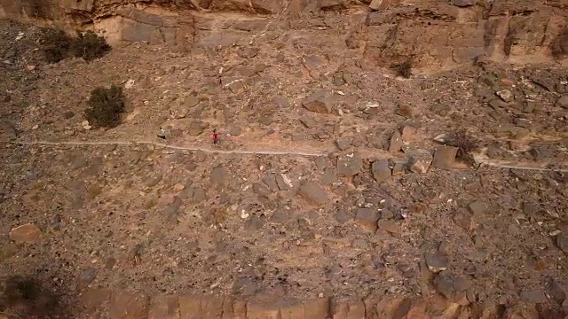 两名越野赛选手在峡谷上方的山道上冲刺视频素材画面3