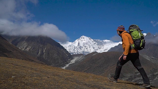 一个背着背包的男人爬上了喜马拉雅山的山坡视频素材