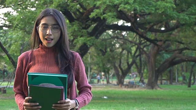 学生拿着学习书籍在大学公园。视频素材