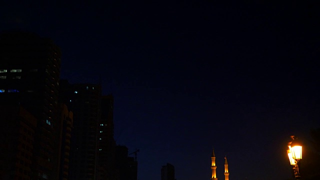 从清真寺到新月的镜头运动。黑暗的阿拉伯之夜。被金色灯光照亮的清真寺。路灯在步行街。视频素材画面2