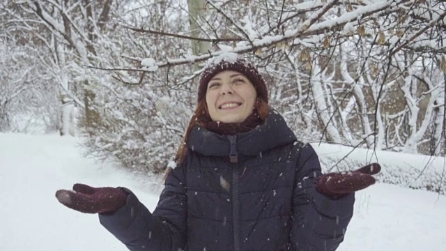 年轻女子在户外享受冬日。雪的冬天的梦想。慢动作视频素材