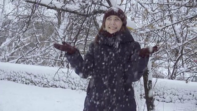 年轻女子在户外享受冬日。雪的冬天的梦想。慢动作视频素材