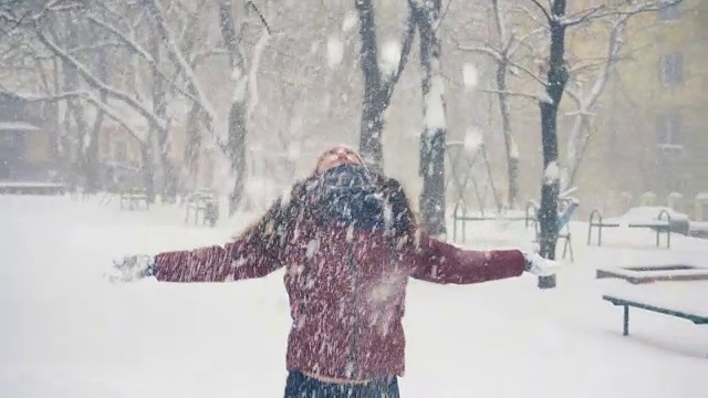 年轻女子在户外享受冬日。雪的冬天的梦想。慢动作视频素材