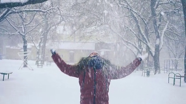 年轻女子在户外享受冬日。雪的冬天的梦想。慢动作视频素材