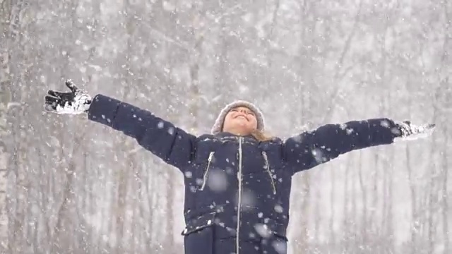 小女孩在雪天张开双臂。视频素材