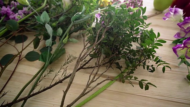 桌上放着几枝绿叶和粉红色的花朵视频素材画面1
